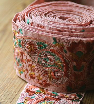 Sidenband i rosa med broderier i rött