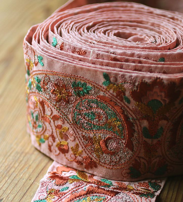 Sidenband i rosa med broderier i rött
