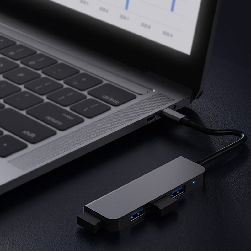 USB-C adapter med fyra USB 3.0-portar ansluten till en laptop.