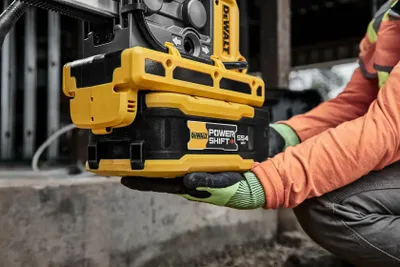 Hantverkare håller DeWalt POWERSHIFT 554 Wh batteri på byggarbetsplats