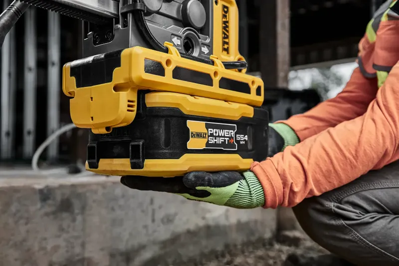 Hantverkare håller DeWalt POWERSHIFT 554 Wh batteri på byggarbetsplats