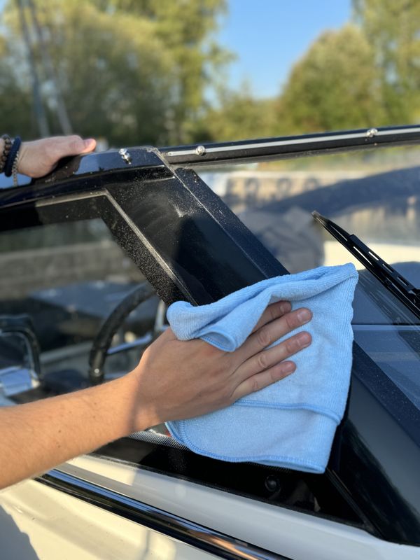 Polerrester torkas bort från båtens gelcoat med en blå All-Purpose Towel