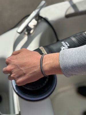 CleanSea-armband på handleden vid polering av båt