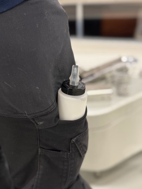 Dispenser Bottle 250 ml förvarad i arbetsbyxornas ficka under polering