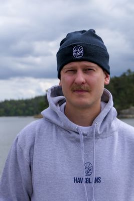 Mörkblå Havsglans Beanie och broderad ikon vid vattnet