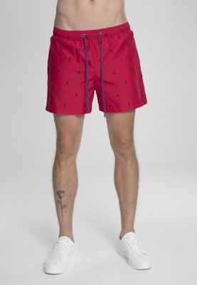 Red swim shorts with embroidered leaves