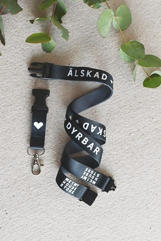 Nyckelband i svart: ÄLSKAD, VÄRDEFULL, DYRBAR