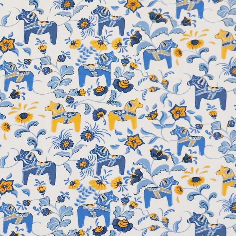 Gots certifierat digitaltryckt trikåtyg med vit botten och dalahästar i Sverige färgerna gult och blått.