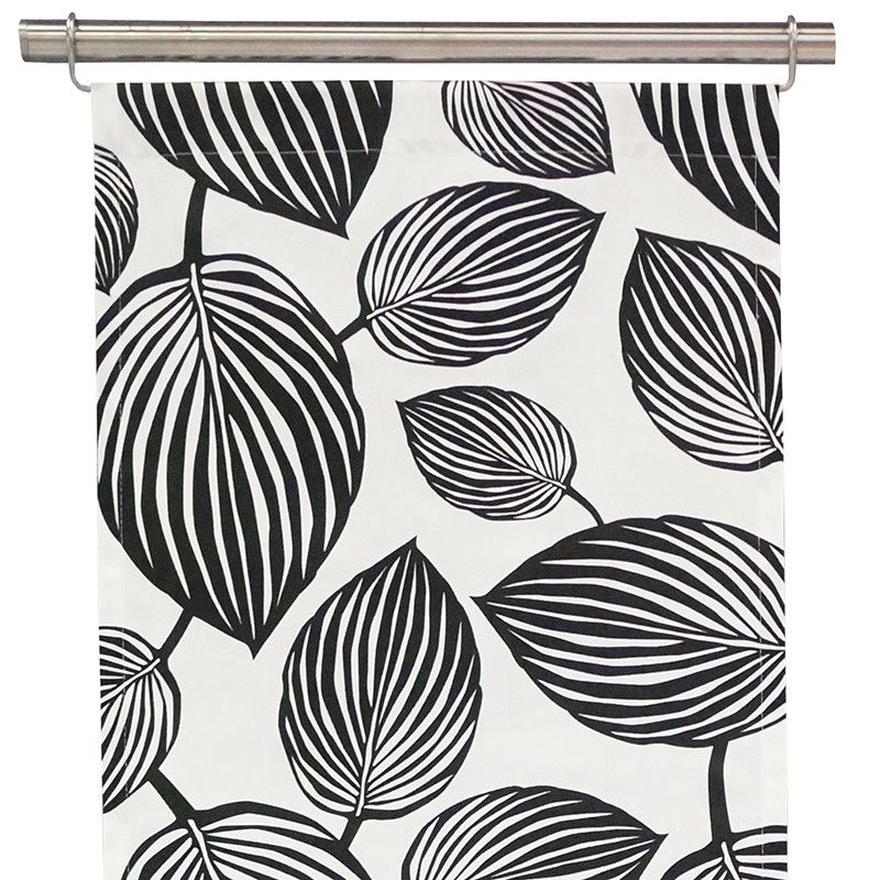 Panelgardiner Lyckans blad vit-svart från Arvidssons textil med vit botten och svarta mönster.