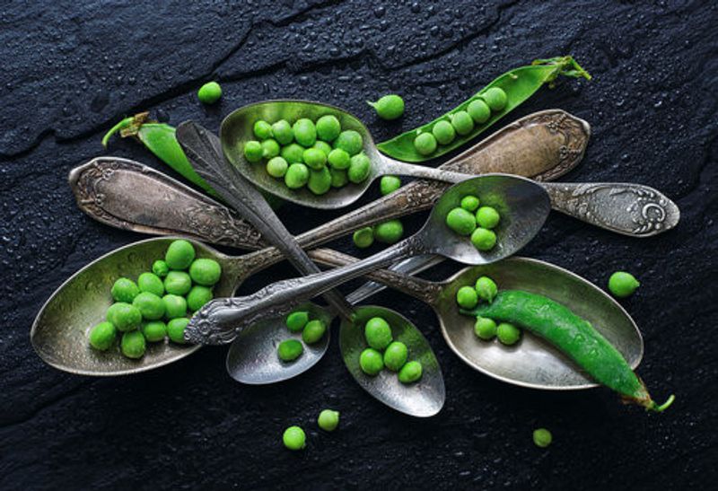Vibrant Green Peas In A Vintage Spoon