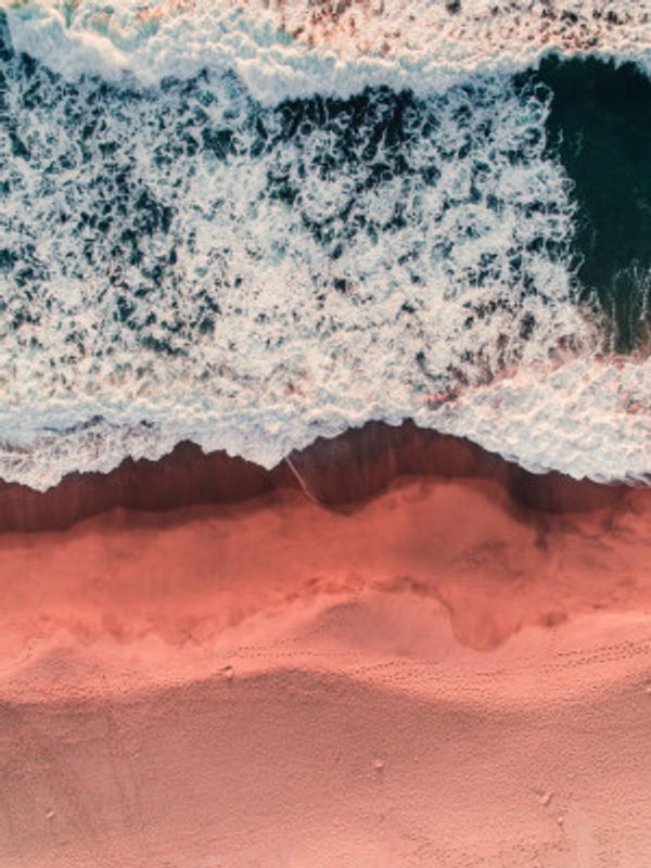 Waves Crashing On A Pink Sandy Beach