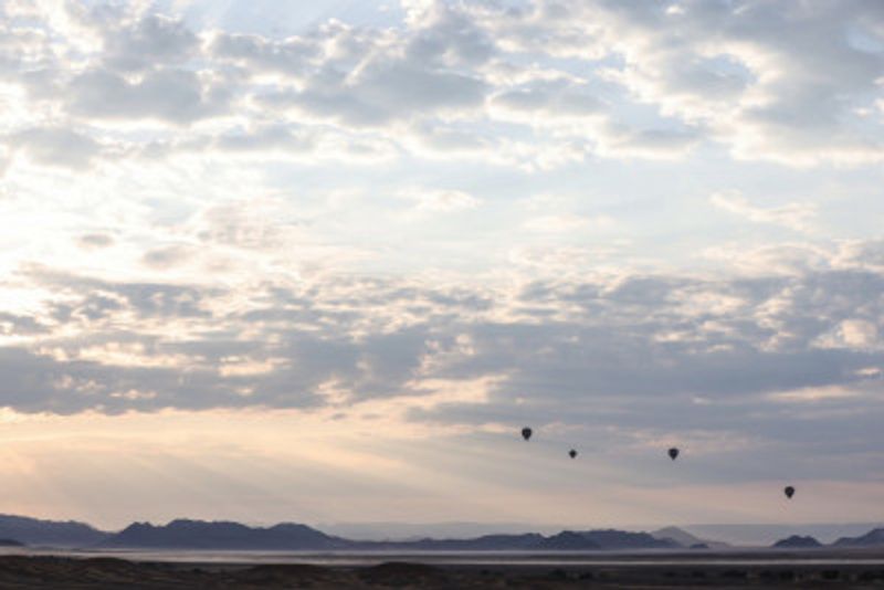 Hot Air Balloons Floating Across A Vast Desert