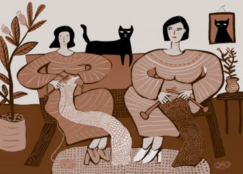 Women knitting on couch with black cat