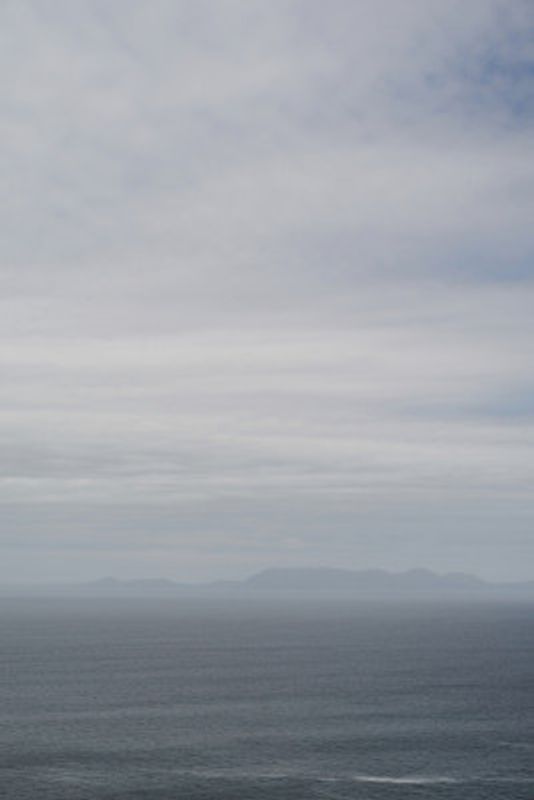 Tranquil Ocean And Distant Horizon Under A Clouded Sky