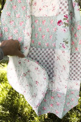 Quiltat blommigt lapptäcke i bomull
