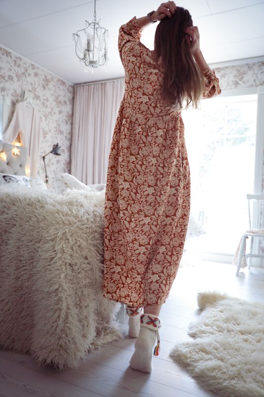 Long romantic dress with a tie at the neckline and small floral vines