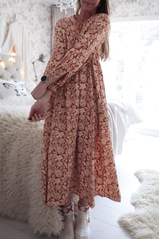 Romantic long dress in a warm, spicy color with natural white floral vines and long sleeves