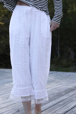 Valkoiset puuvillahousut, joissa on pitsireunus