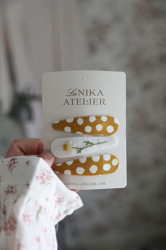 Tre handgjorda hårspännen i gult och naturvitt tyg med broderad blomma