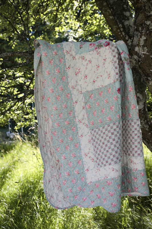 Quiltat blommigt lapptäcke i bomull