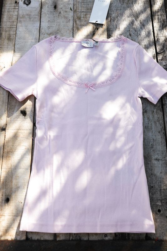 Ribbed pink top with lace and a bow