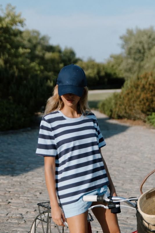 Modell i blå randig t-shirt i somrig miljö