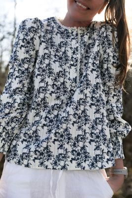 Blommig bomullsblus med spetsdetaljer på modell