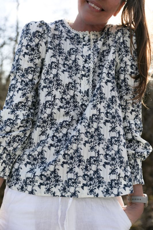 Blommig bomullsblus med spetsdetaljer på modell