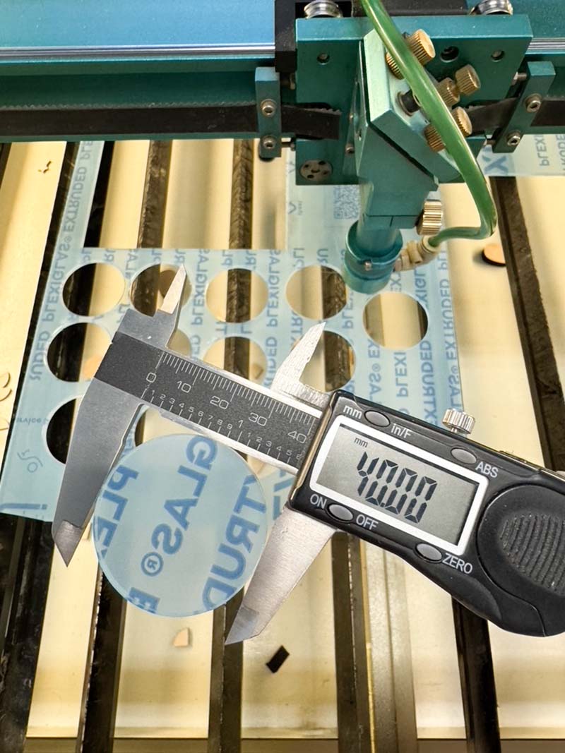 Laserskärning av plexiglas Lasermaskin med utskuren plexiglas som kontrolleras med skjutmått och mäter exakt 40,00 mm