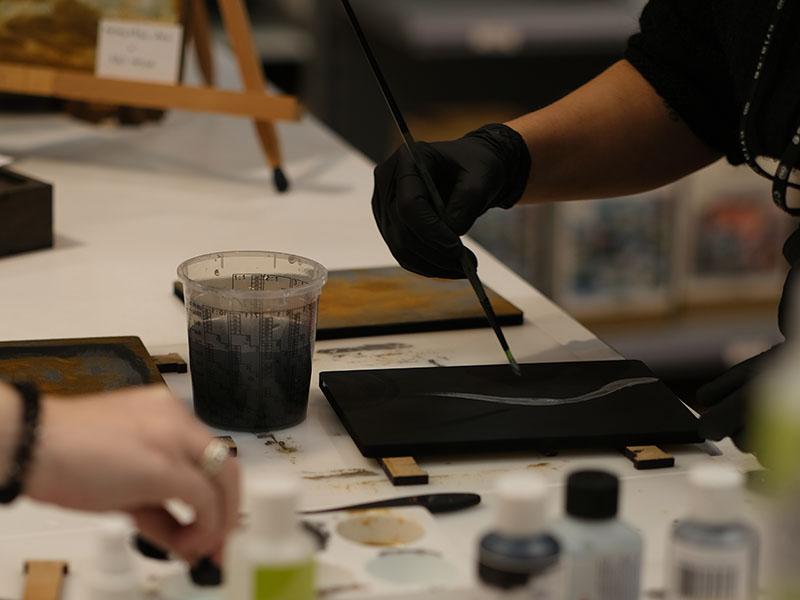 Gruppevent hos Cria Bord med kreativa produkter och två händer som arbetar med dem