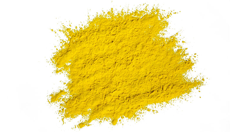 Gult färgpigment på vit yta