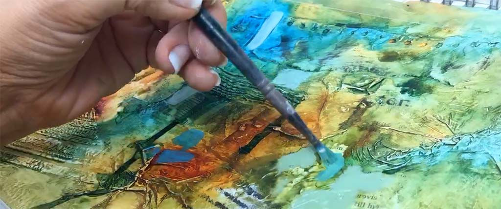 En mixed-mediatavla med en hand som målar med en pensel. Företags-aktivitet i Linköping.