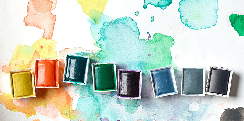 Flera akvarellfärger i halvkopp uppradade på akvarellpapper, Winsor & Newton Professional