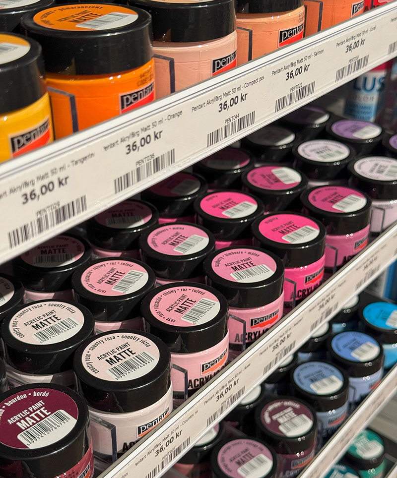 Butikshylla med Pentart Matt akrylfärg. På bilden finns flera olika kulörer och hyllkantsetiketter med namn, pris, artikelnummer och EAN-kod