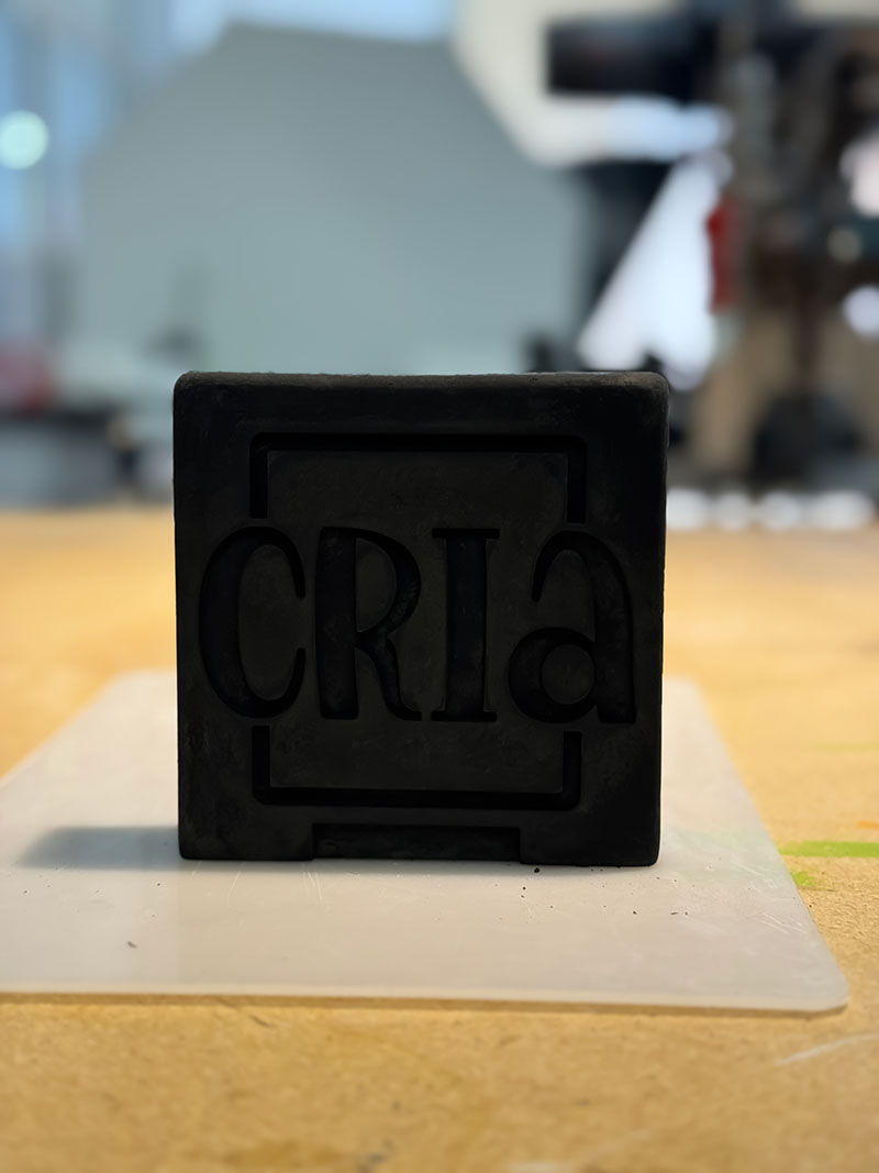 Bild av vår logga, Cria, gjuten i betong med extra svart färgpigment